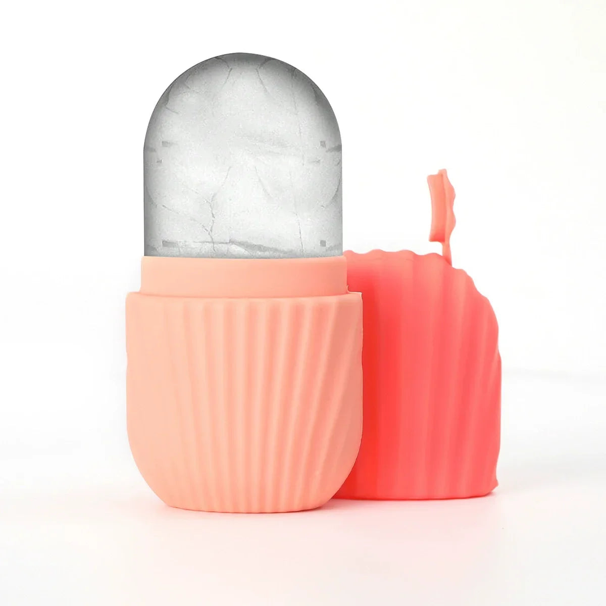 Peach-colored silicone ice face roller with a detached ribbed cap and a rounded, frozen ice core.