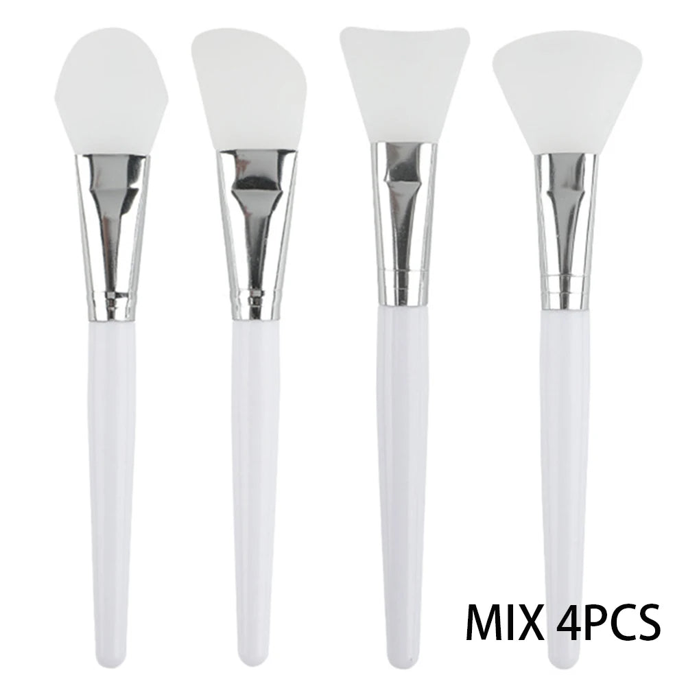 Four silicone face mask brushes with white handles, silver ferrules, and various head shapes for smooth application.