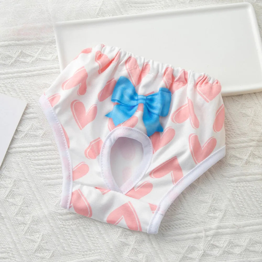 Washable dog diaper with pink heart pattern and blue bow for female pet hygiene and menstruation protection.
