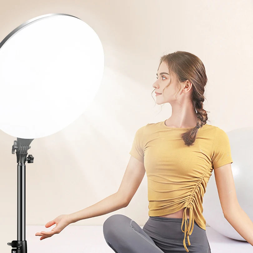 Large circular LED ring light on an adjustable metal stand, used for professional photography and content creation.