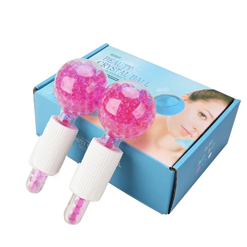 Two glass facial massage globes with pink beads, featuring white foam grips, shown with their blue packaging box.