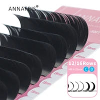 Black synthetic individual eyelash extension strips on a pink tray for professional lash application.