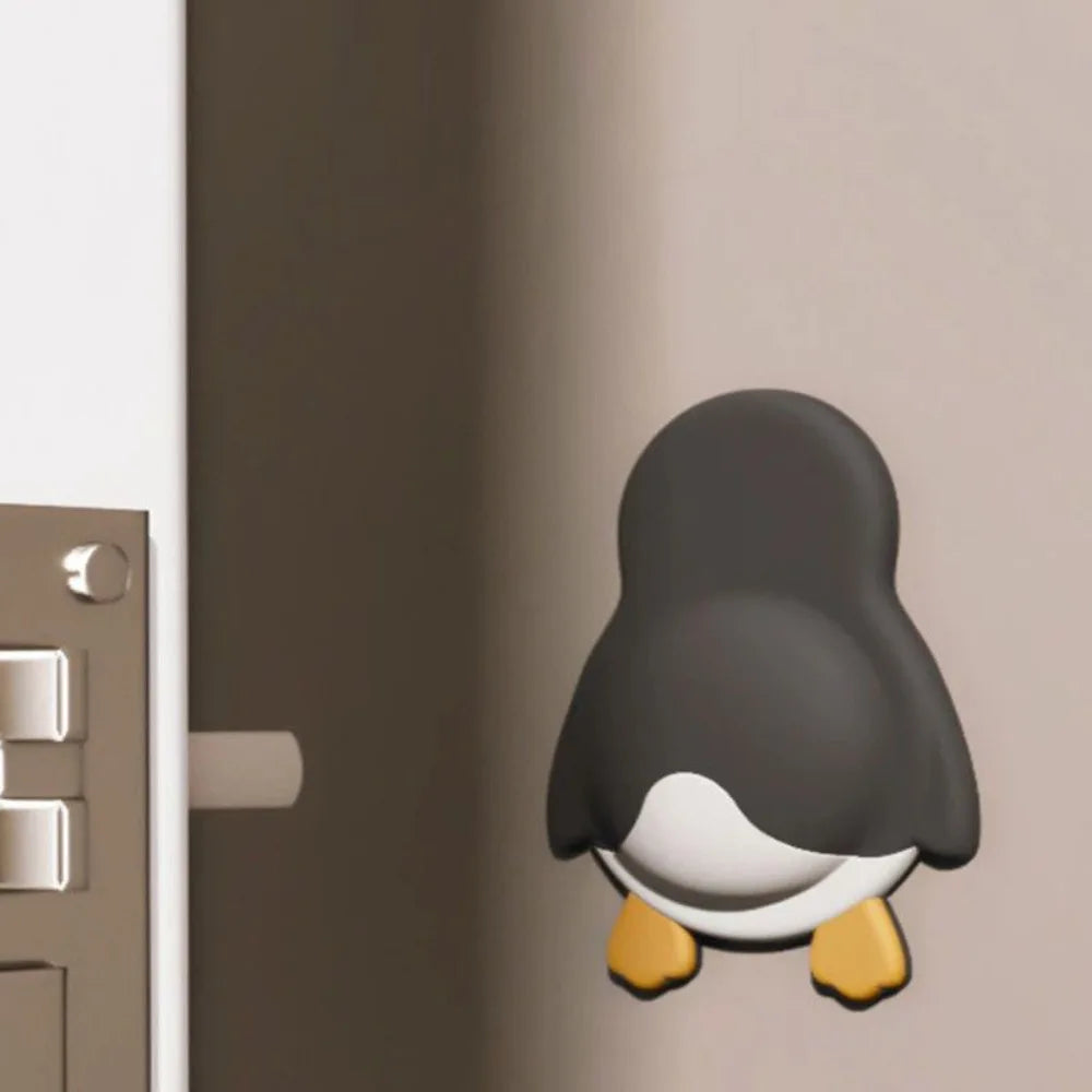 Cute penguin adhesive door stopper wall bumper to prevent damage from slamming doors. Durable home decor protection.
