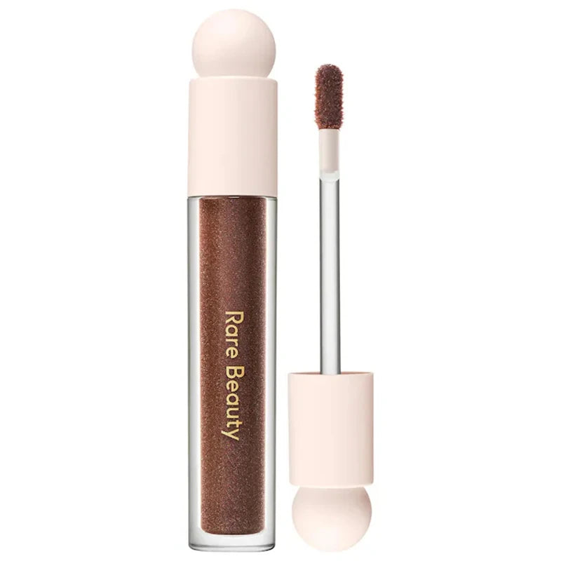 Rare Beauty Soft Pinch Tinted Lip Oil in a deep brown shade with a doe-foot applicator and matte beige cap.