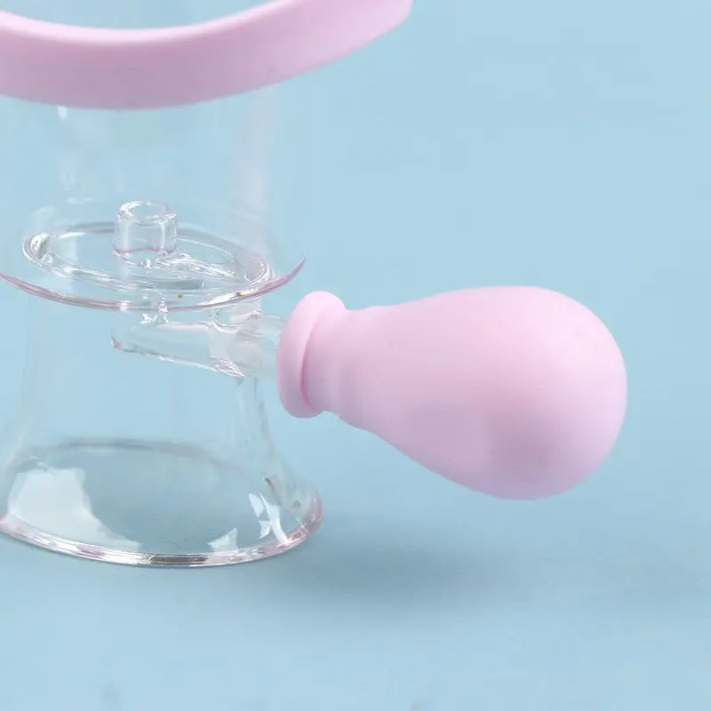 Reusable pink silicone eye wash cup with manual squeeze bulb for gentle eye rinsing and flushing on blue background.