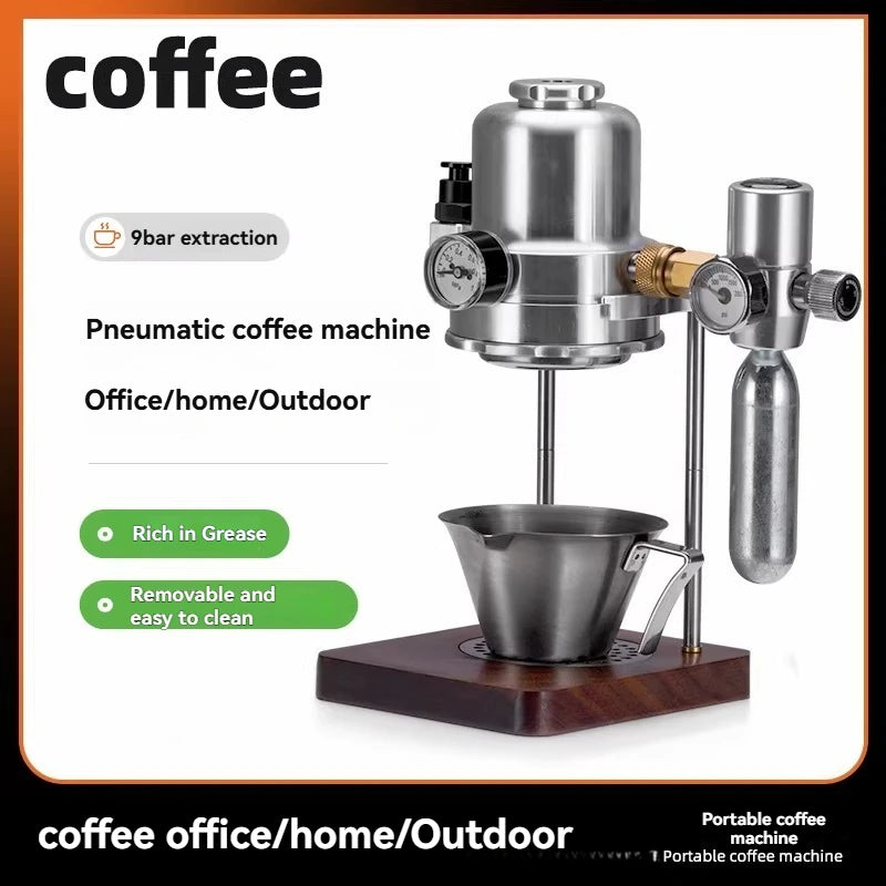 Portable stainless steel pneumatic coffee machine with pressure gauges, metal cup, and wooden base for home or office.