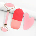 Three-piece facial tool set: rose gold jade roller, red/pink silicone ice roller, and a heart-shaped pink gua sha stone.