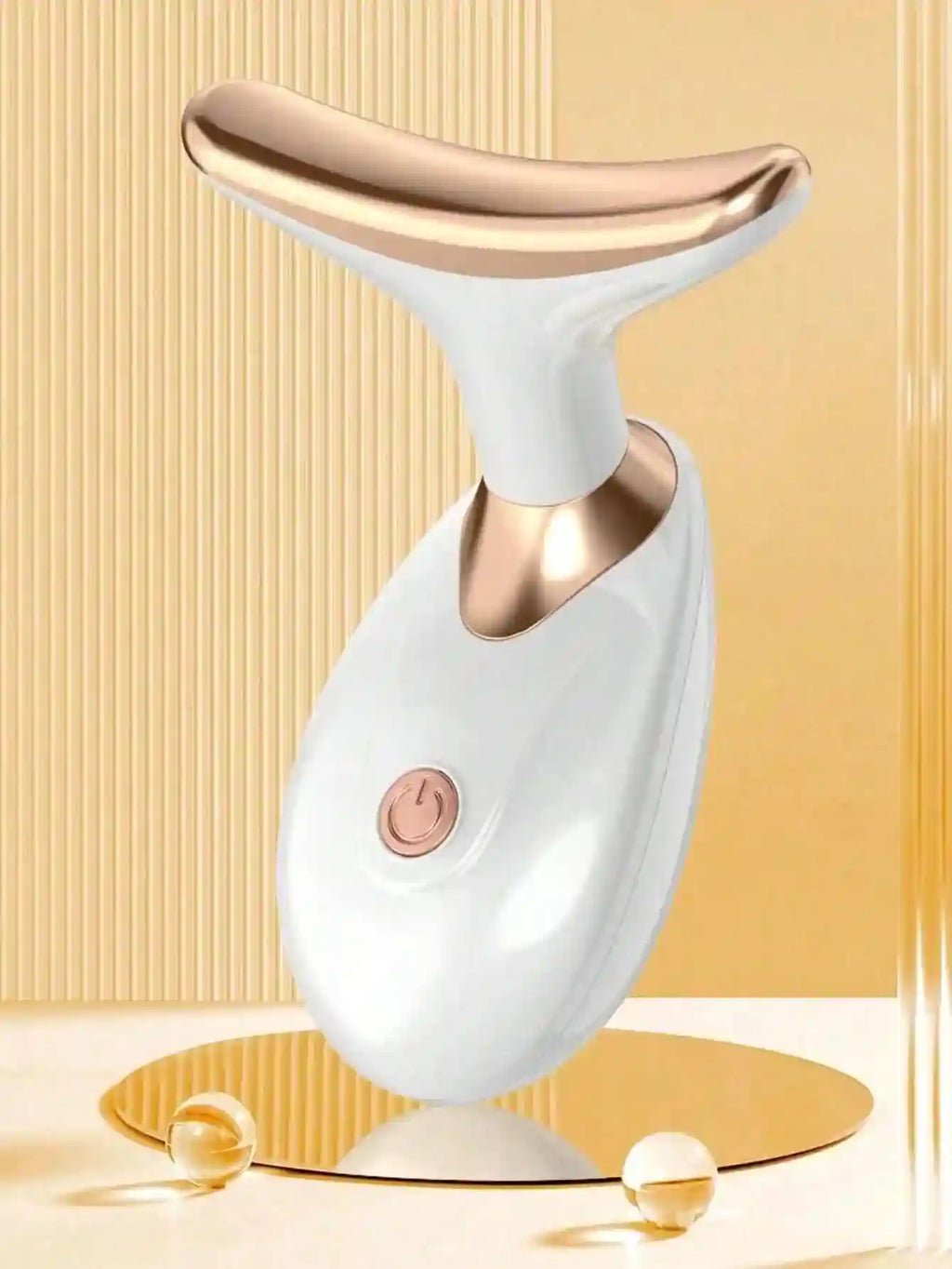 White and rose gold T-shaped facial massager with a circular power button, set against a gold fluted background.