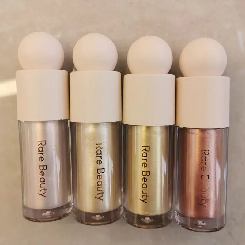 Four Rare Beauty Positive Light Liquid Luminizer highlighter bottles in assorted shimmering metallic shades.
