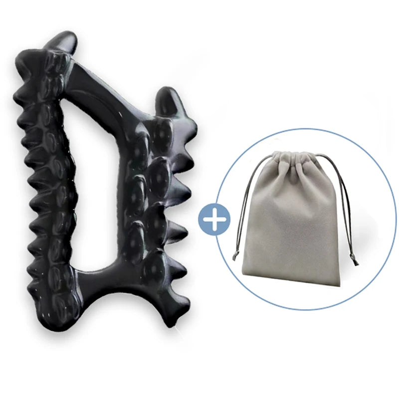 Black plastic handheld body massage tool with textured nodules, accompanied by a small grey fabric drawstring pouch.