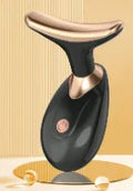 Black and gold facial massager with a curved, T-shaped head and a sleek, handheld ergonomic design.