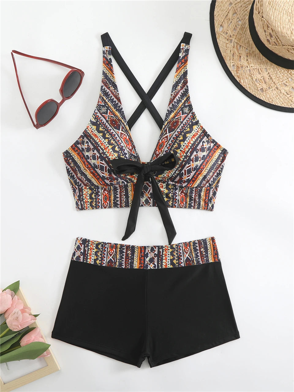Tidesmit high-waisted bikini with tribal print top, black bow-tie front, crisscross straps, and black swim shorts.
