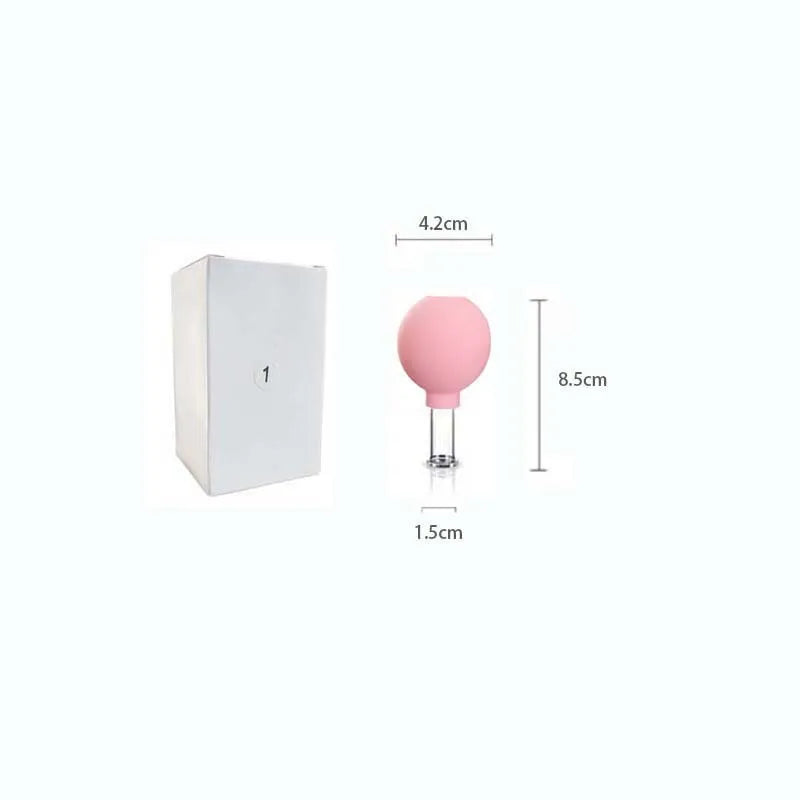 Pink facial cupping tool with a glass base and rubber bulb, shown with dimensions, next to its white storage box.