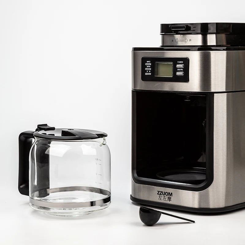 ZZUOM stainless steel drip coffee maker with glass carafe, digital display, and measuring scoop on white background.