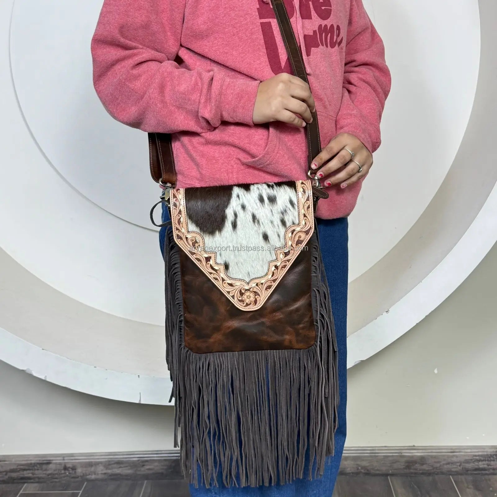 Vintage floral tooled brown leather fringe crossbody handbag with black and white cowhide flap for women.