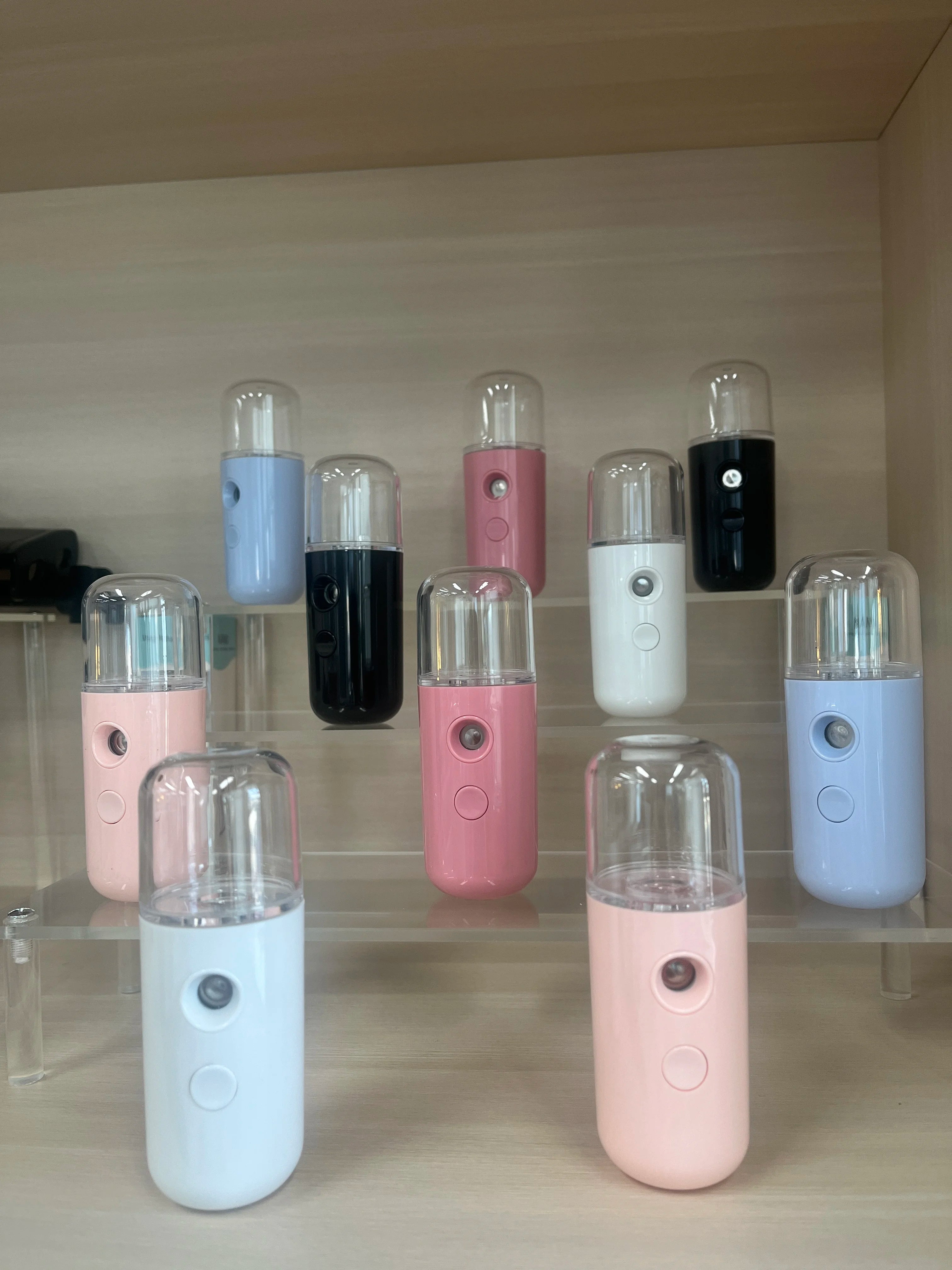 Portable nano facial mister sprayers in various colors for skin hydration, eyelash care, and makeup setting.