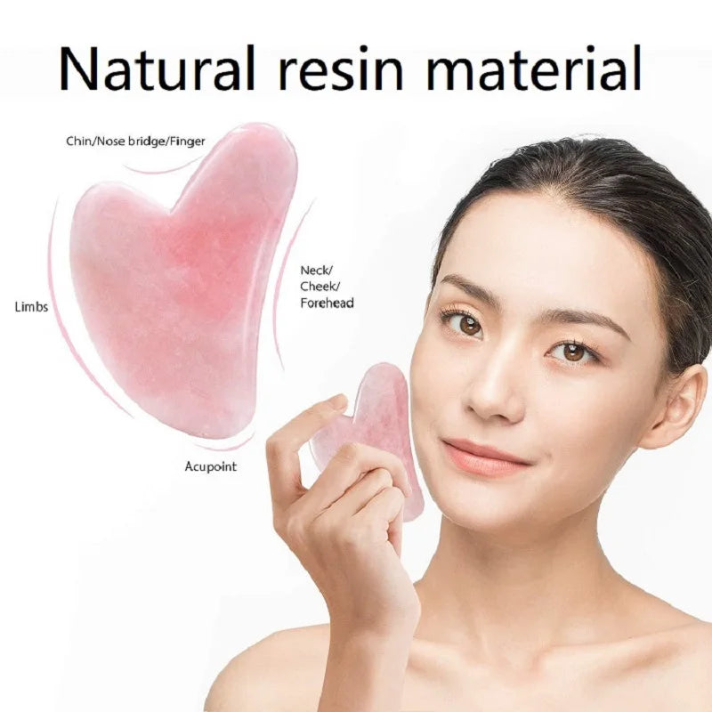 Woman using a pink, heart-shaped resin gua sha massage stone on her cheek; diagrams show facial application areas.