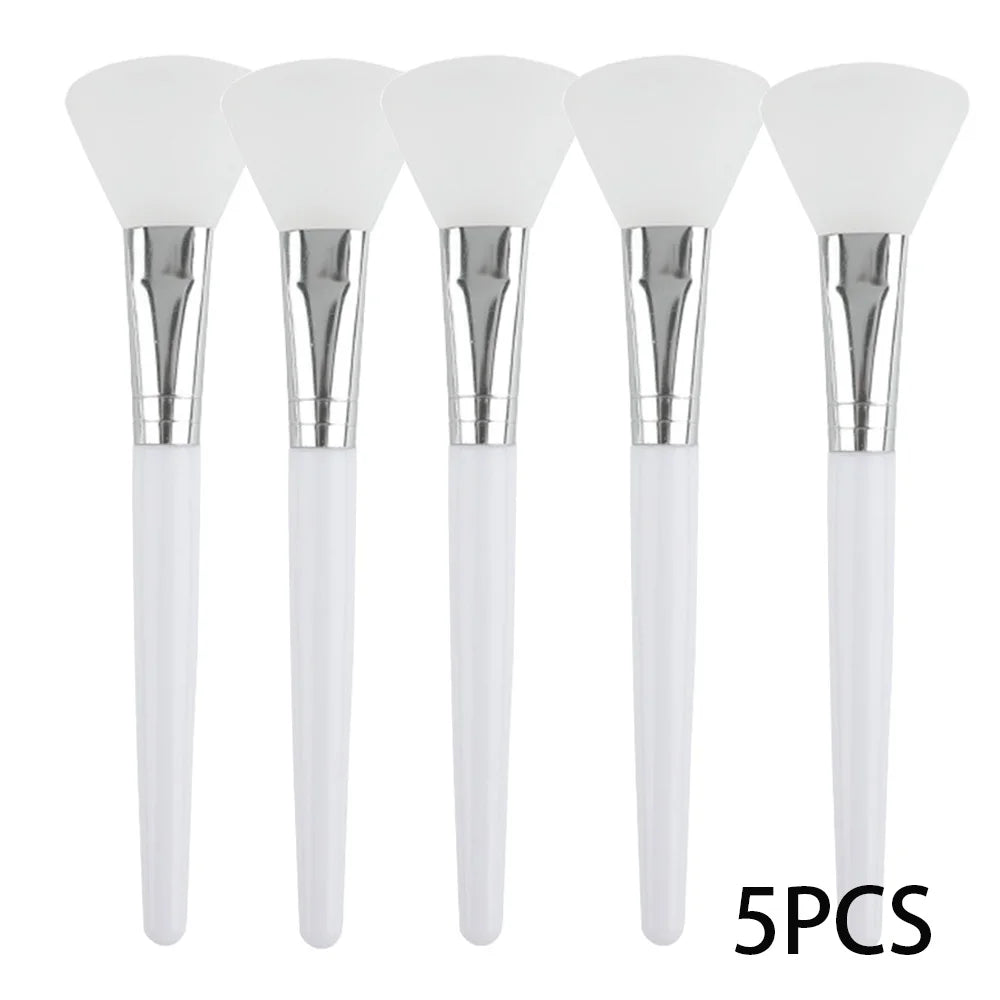 Five white silicone face mask applicator brushes with silver ferrules and white handles lined up vertically.