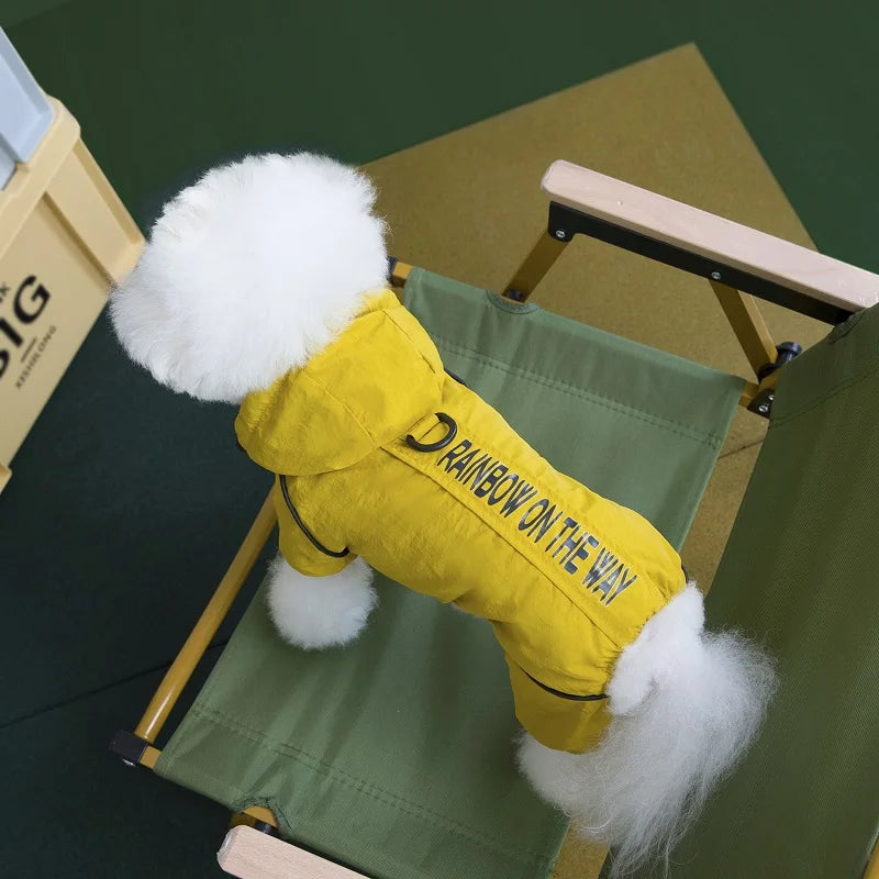 Small dog wearing a waterproof yellow hooded winter jumpsuit to stay warm and dry outdoors.