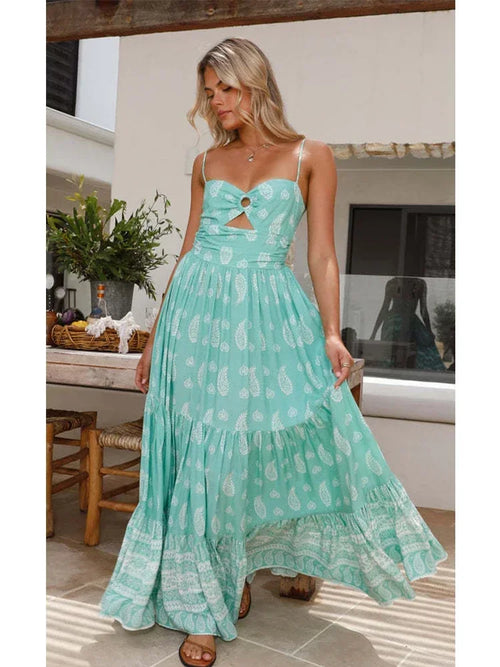 Woman wearing a turquoise paisley-print maxi sundress with spaghetti straps and a chest cut-out detail.