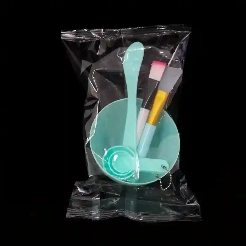 A 7-piece DIY face mask tool kit in a clear plastic bag, including a mint-green bowl, spatula, brushes, and scoops.