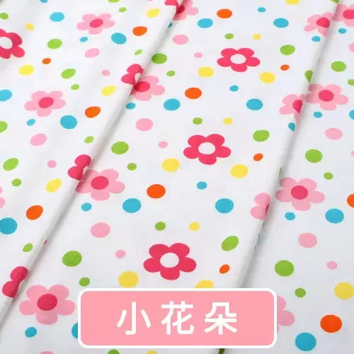Tidesmit white knit jersey fabric featuring a colorful print of pink flowers and multi-colored polka dots.