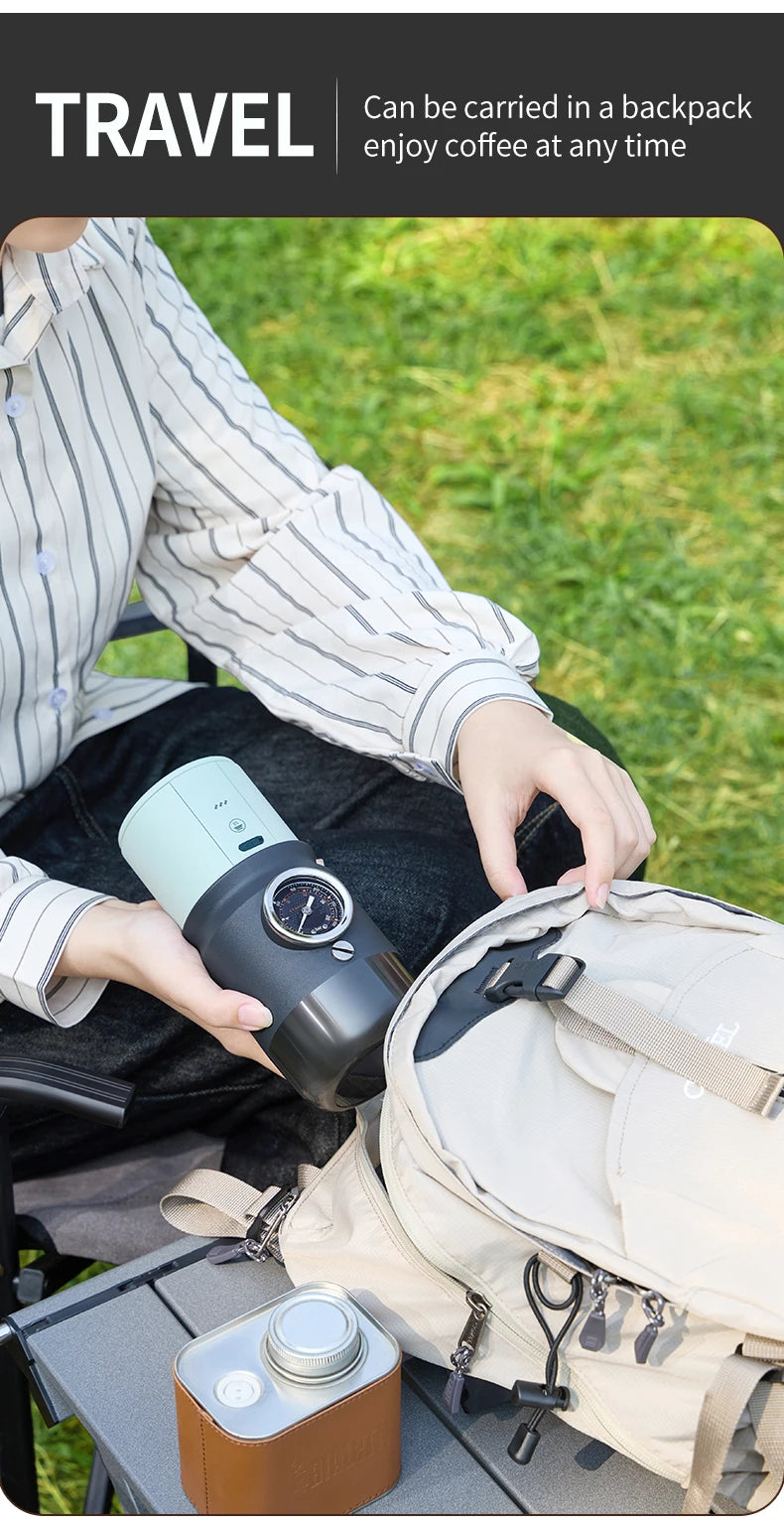 Portable two-tone blue and black travel coffee maker with pressure gauge being packed into a backpack outdoors.