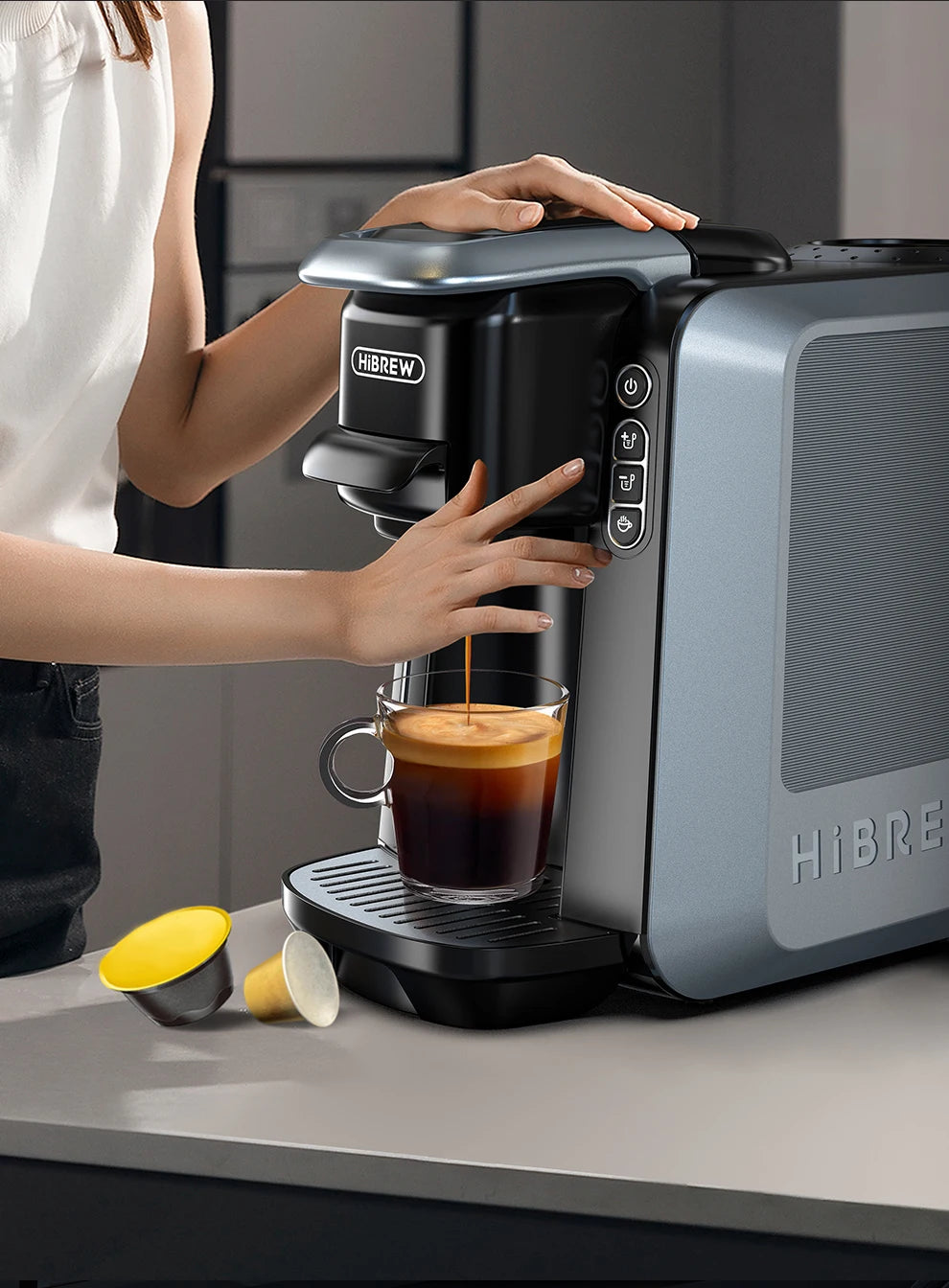 HiBrew multi-capsule espresso coffee maker in grey and black brewing fresh coffee into a glass cup.