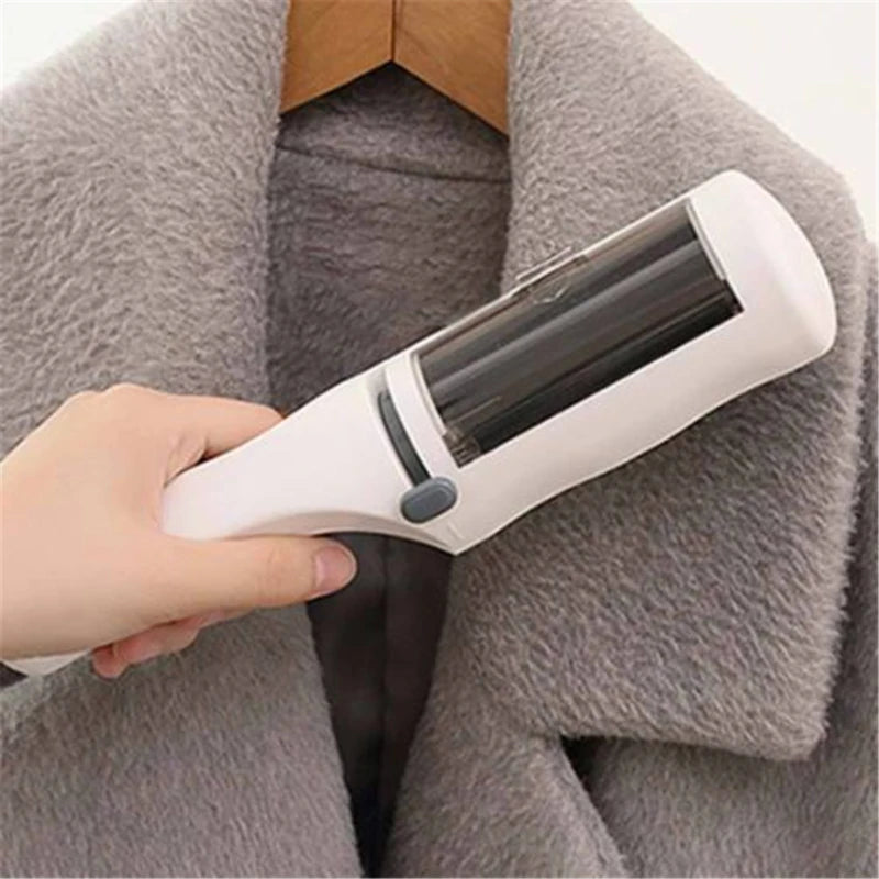 White self-cleaning electrostatic lint brush removing dog and cat hair from a grey winter coat.