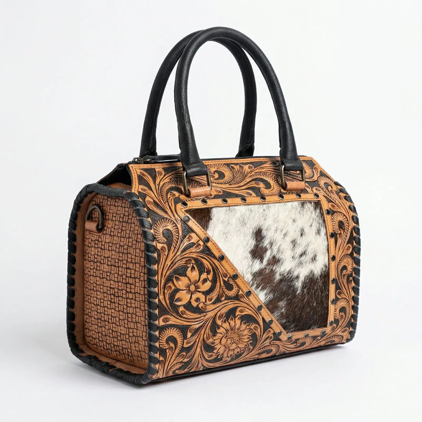 Handmade designer weekender bag in tooled leather and cowhide with floral carvings and black leather top handles.