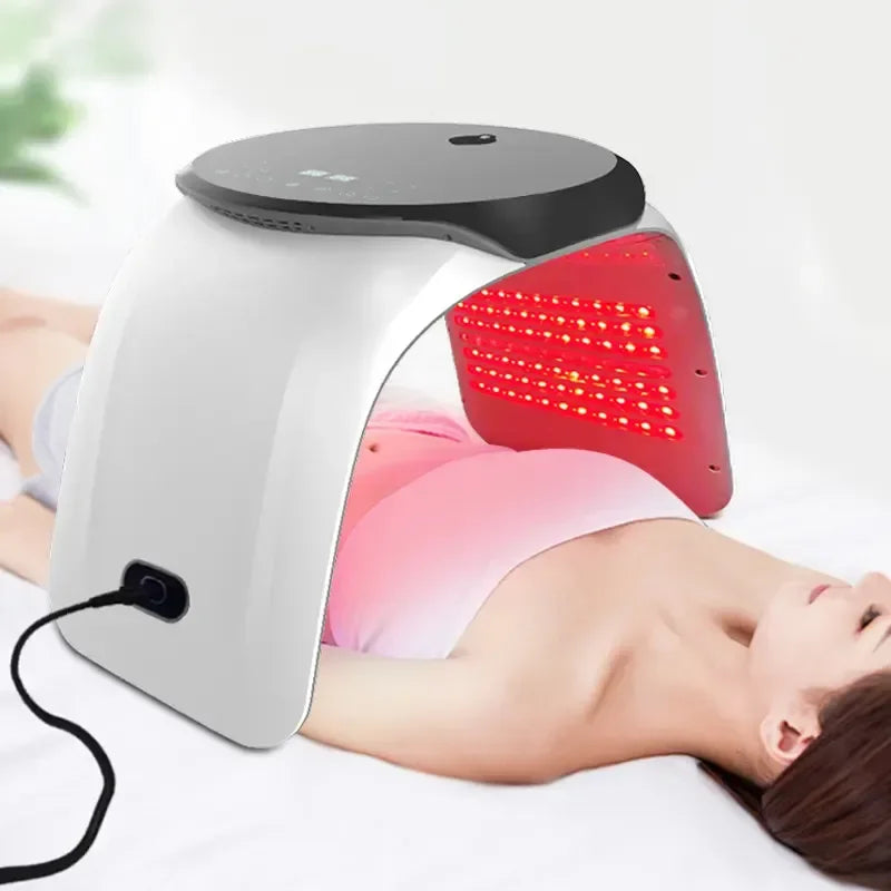 7-color LED light therapy arch for home skin rejuvenation with red light emission over a woman lying down.