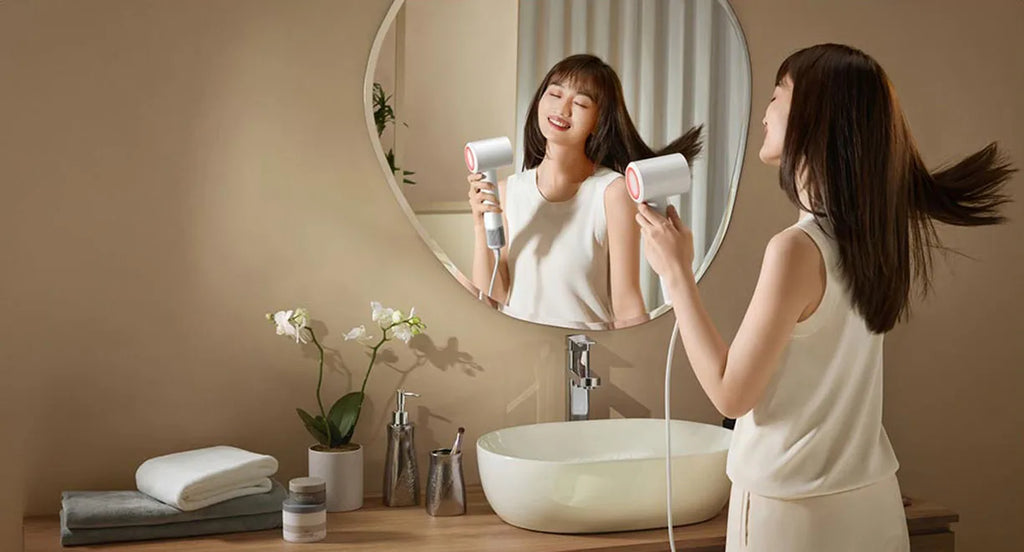 Woman using white MIJIA H501SE high-speed hair dryer for fast, negative ion hair drying in a modern bathroom.
