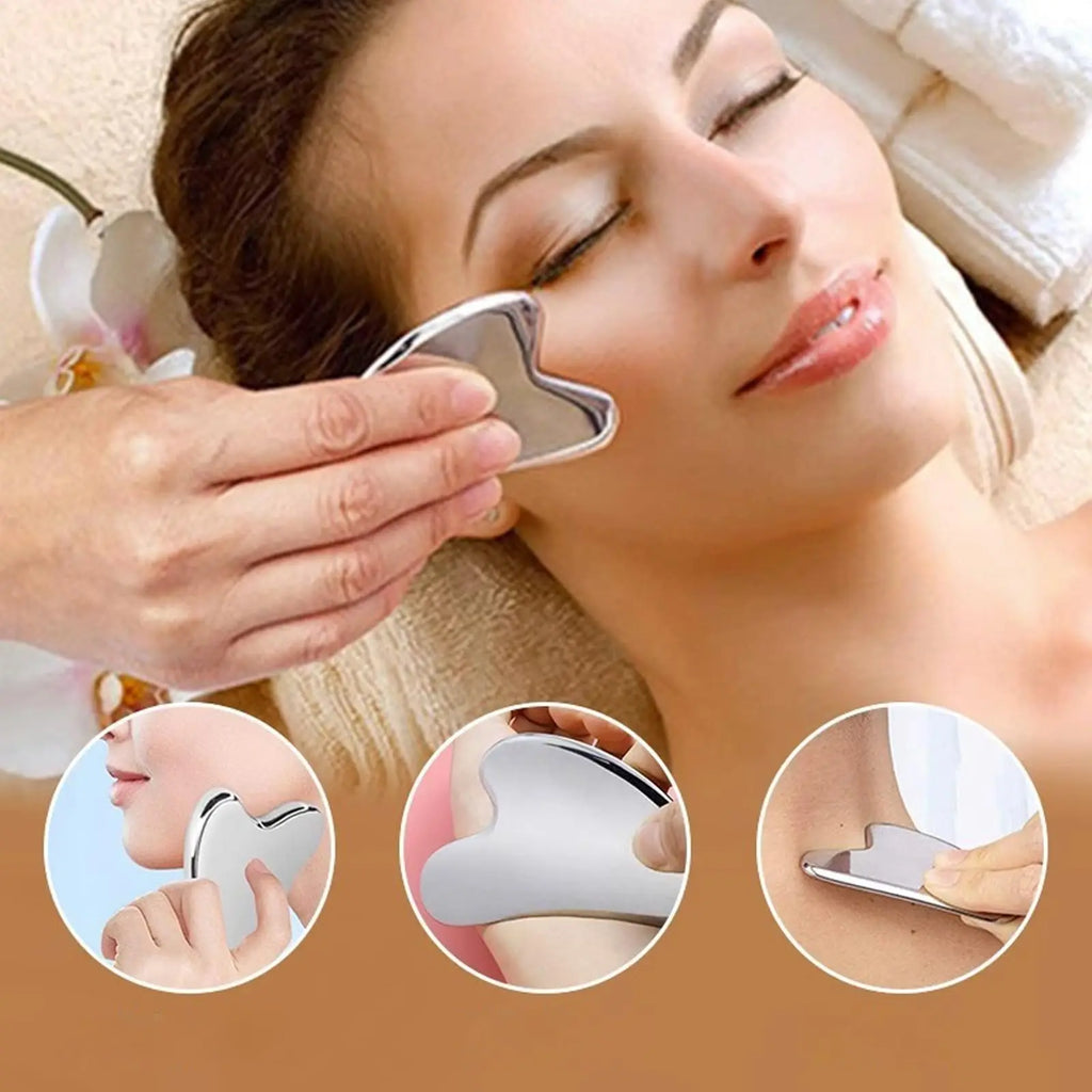 Silver stainless steel heart-shaped gua sha tool being used to massage the face and neck.