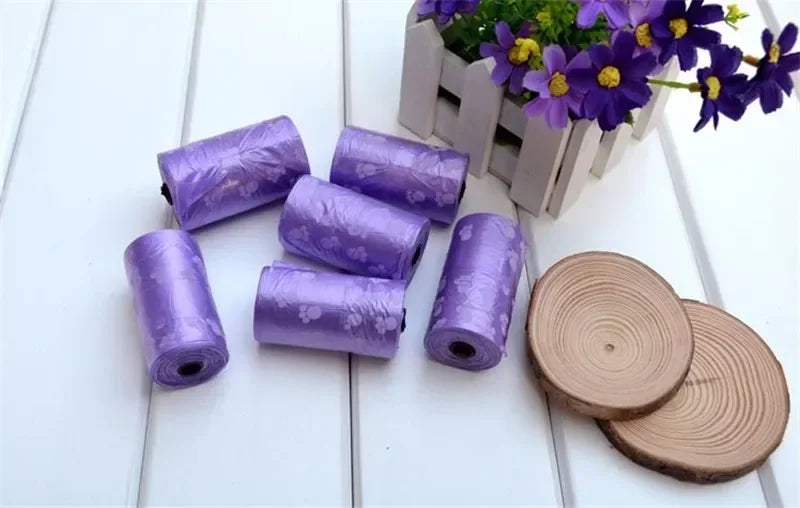 Purple leak-proof dog poop bag rolls with paw prints for easy, clean pet waste disposal.