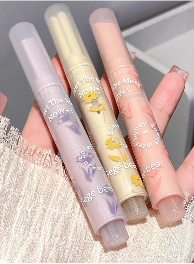 Gege Bear Floral Whisper glossy lipsticks in pastel purple, yellow, and pink tubes with floral designs held in hand.