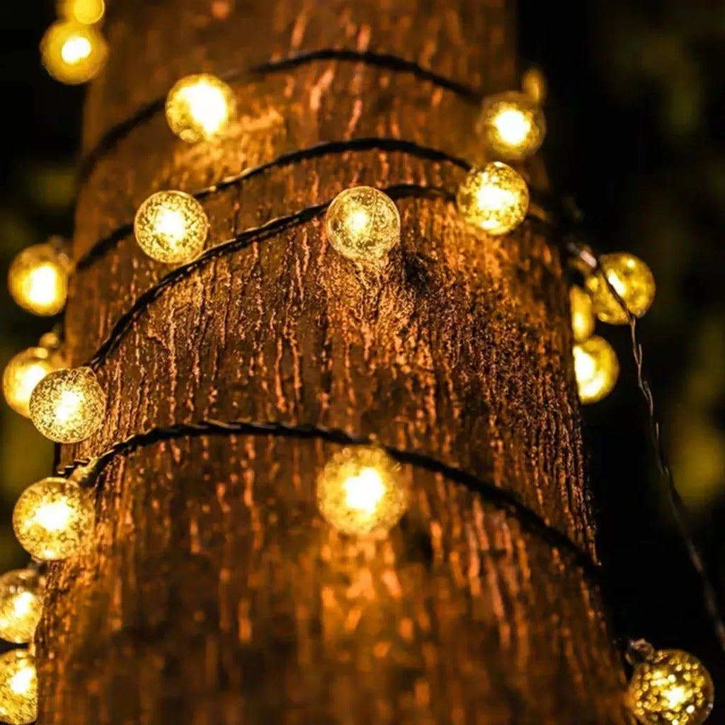 Close-up of warm golden bubble globe bulbs on a solar string light line