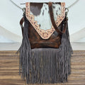 Vintage floral tooled leather fringe crossbody bag with brown cowhide accents. Designer boho style shoulder handbag.