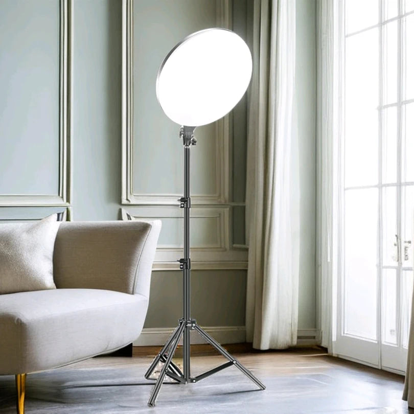 Large circular LED ring light on an adjustable black tripod stand, used for professional photography and video lighting.