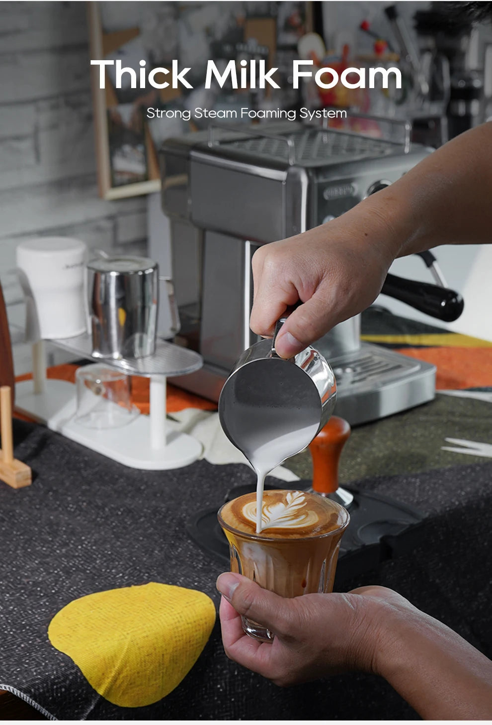 Stainless steel espresso machine pouring thick milk foam into a latte glass for latte art.