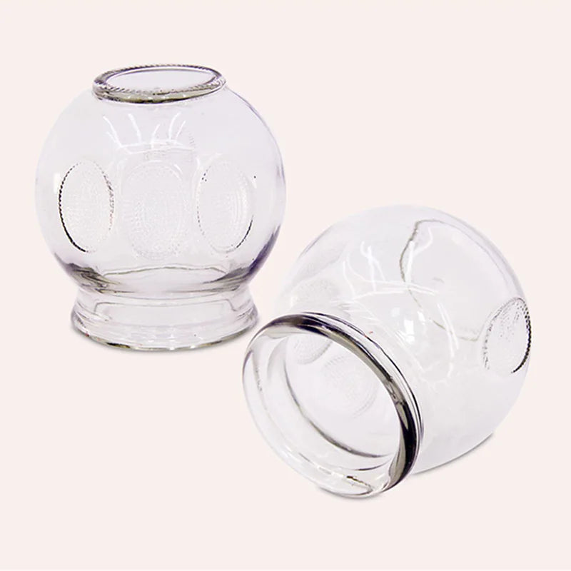Two durable, extra-thick clear glass cupping therapy jars with textured grip for professional or home fire cupping.