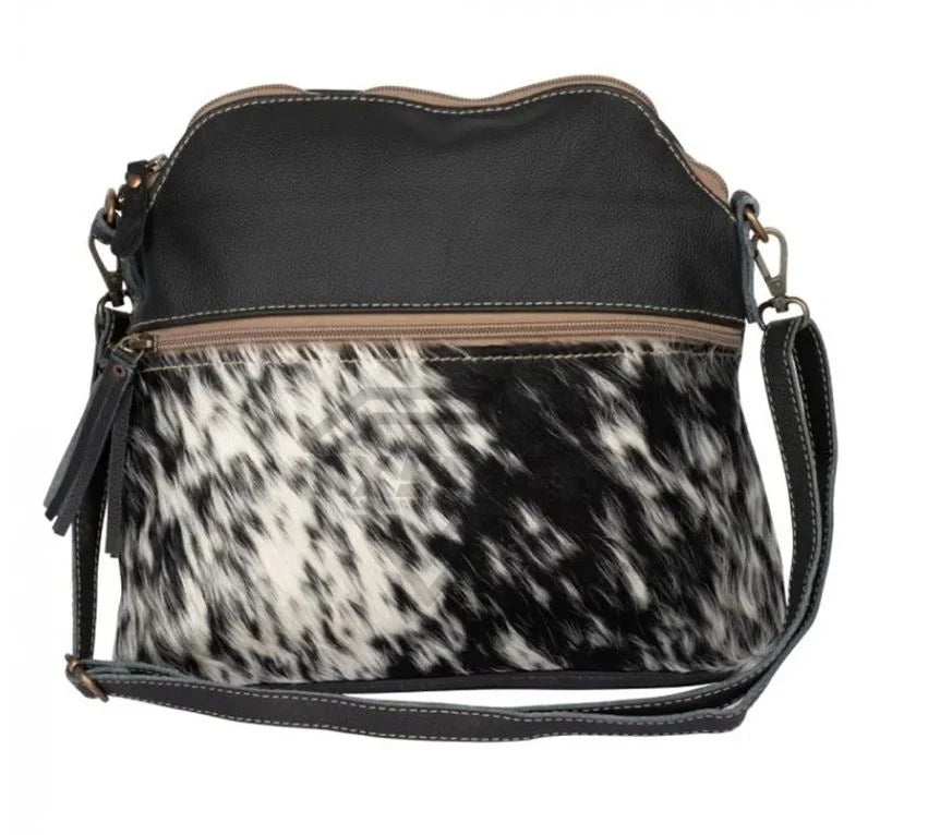 Black leather and cowhide hair-on crossbody handbag with zipper pocket and adjustable shoulder strap. Designer style.