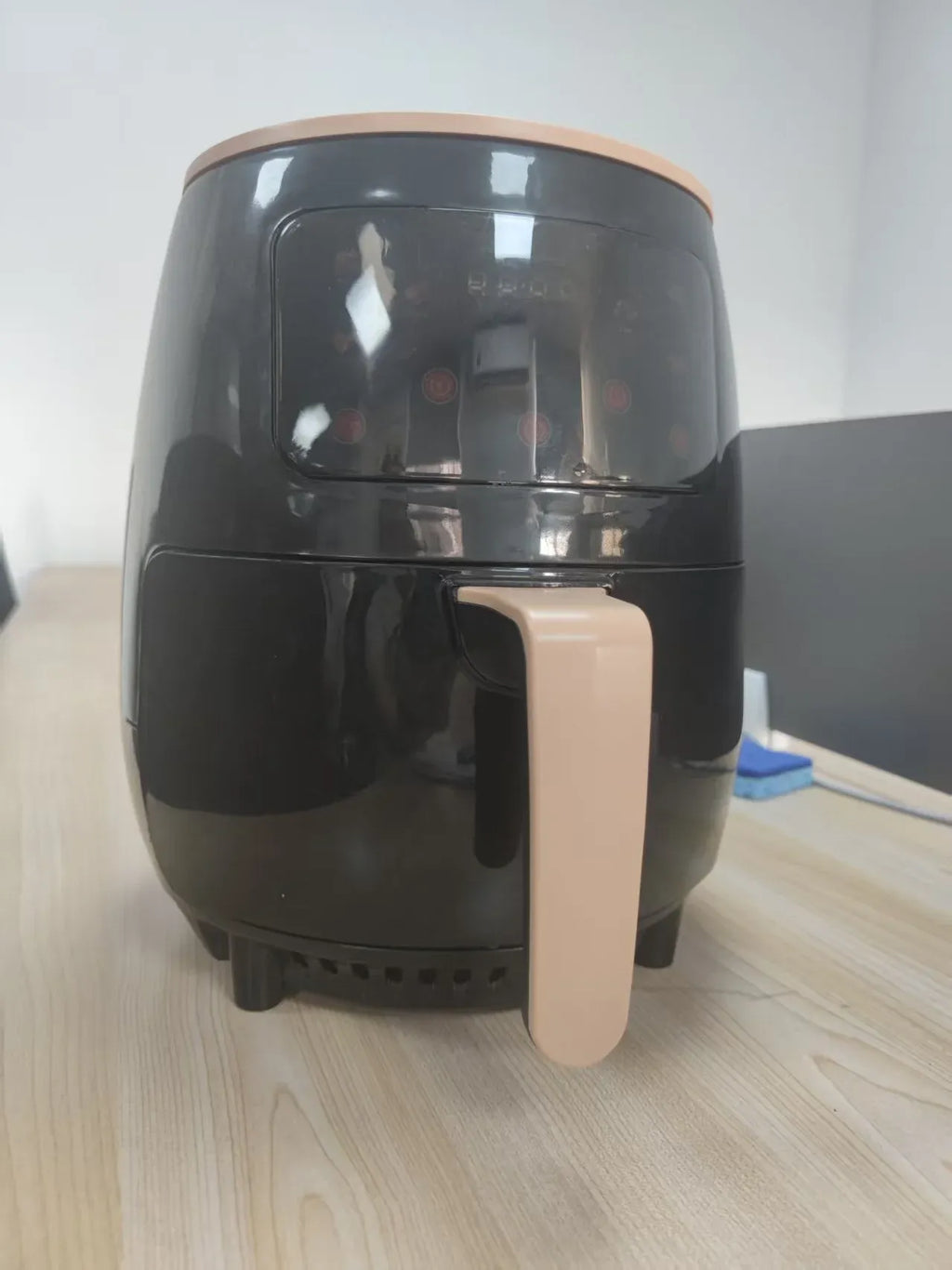Black air fryer with cream pull handle and glossy top lid