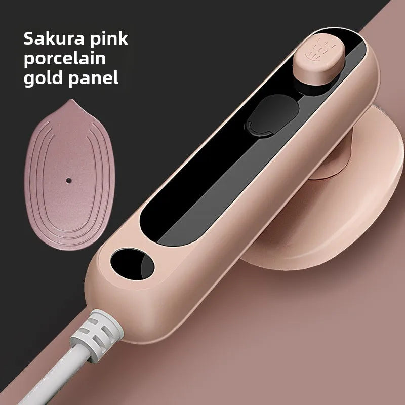 Sakura pink handheld steam iron with porcelain-gold panel and black steam window