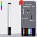 Handheld RGB LED light tube with a black handle, charger, and remote, used for photography and creative lighting.