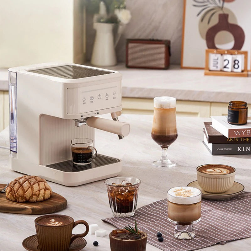 Cream-colored compact espresso coffee machine with portafilter on a kitchen counter with various coffee drinks.