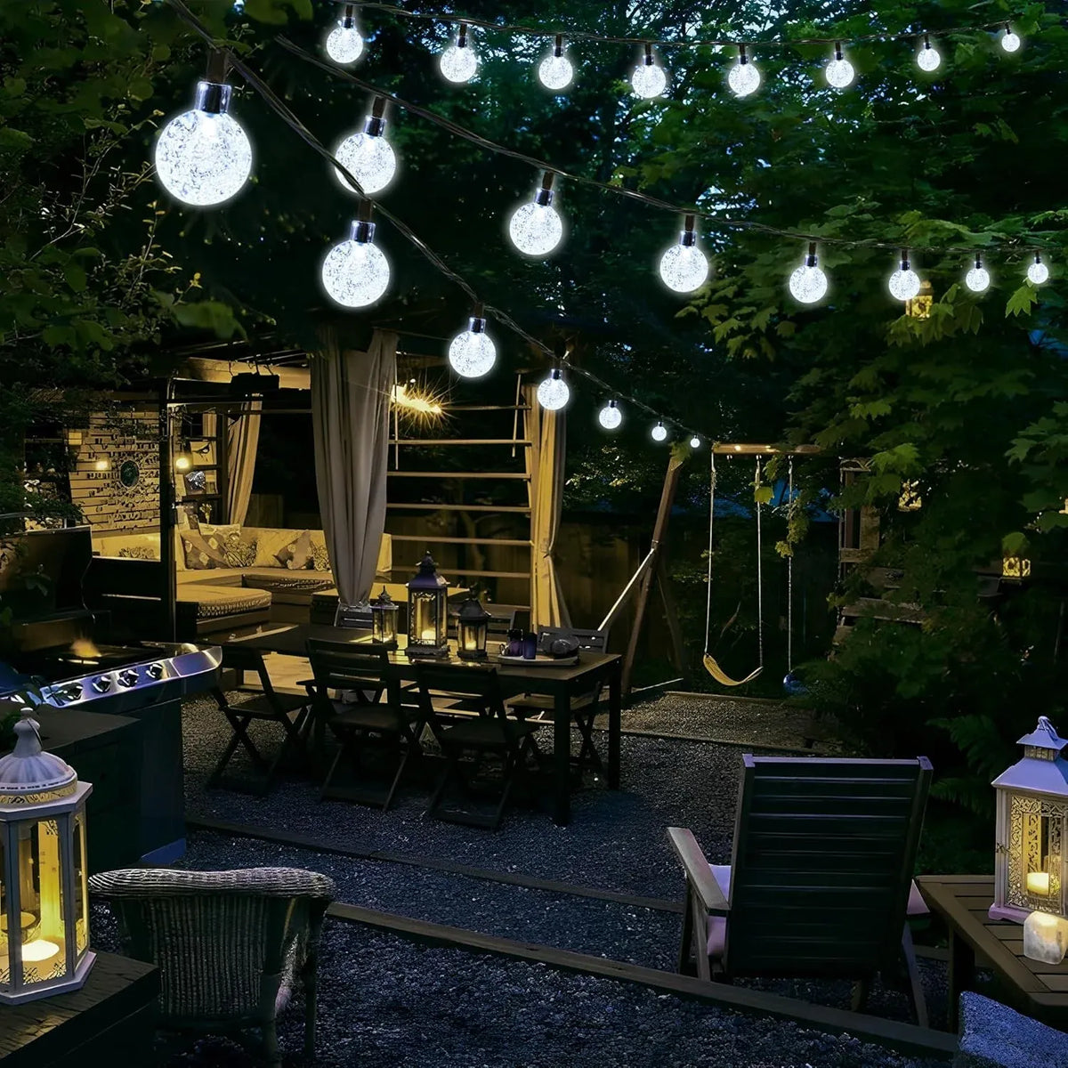 White LED globe string lights hanging over an outdoor seating area with bright round bulbs in trees.