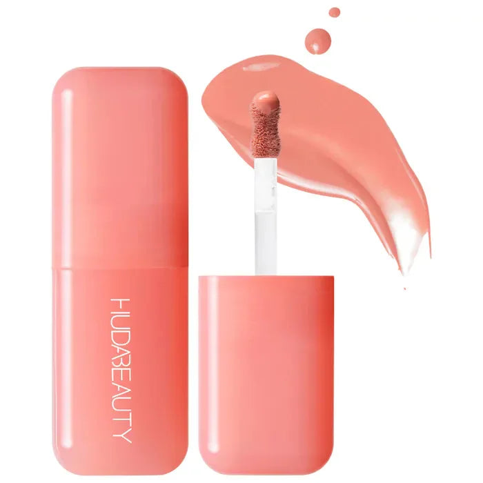 Huda Beauty hydrating lip and cheek tint stick in peachy-pink with a creamy, smooth applicator swatch.