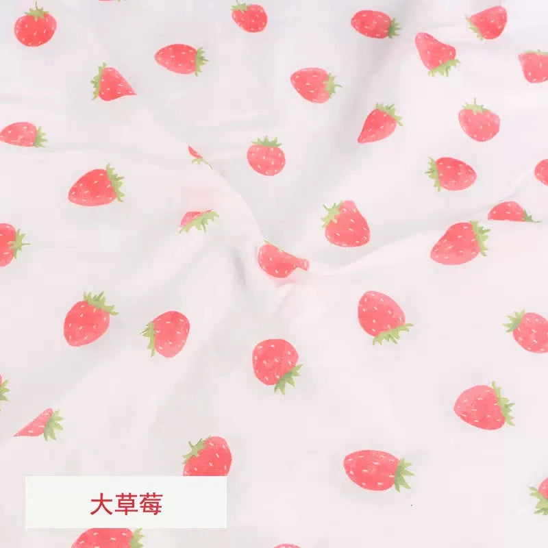 Soft white Tidesmit knit jersey fabric featuring a repeating pattern of small pink strawberries for baby garments.