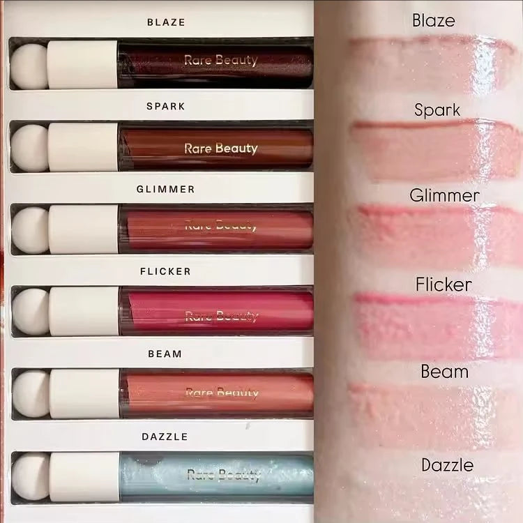 Rare Beauty Soft Pinch Tinted Lip Oil swatches showing glossy texture and various shades on arm.