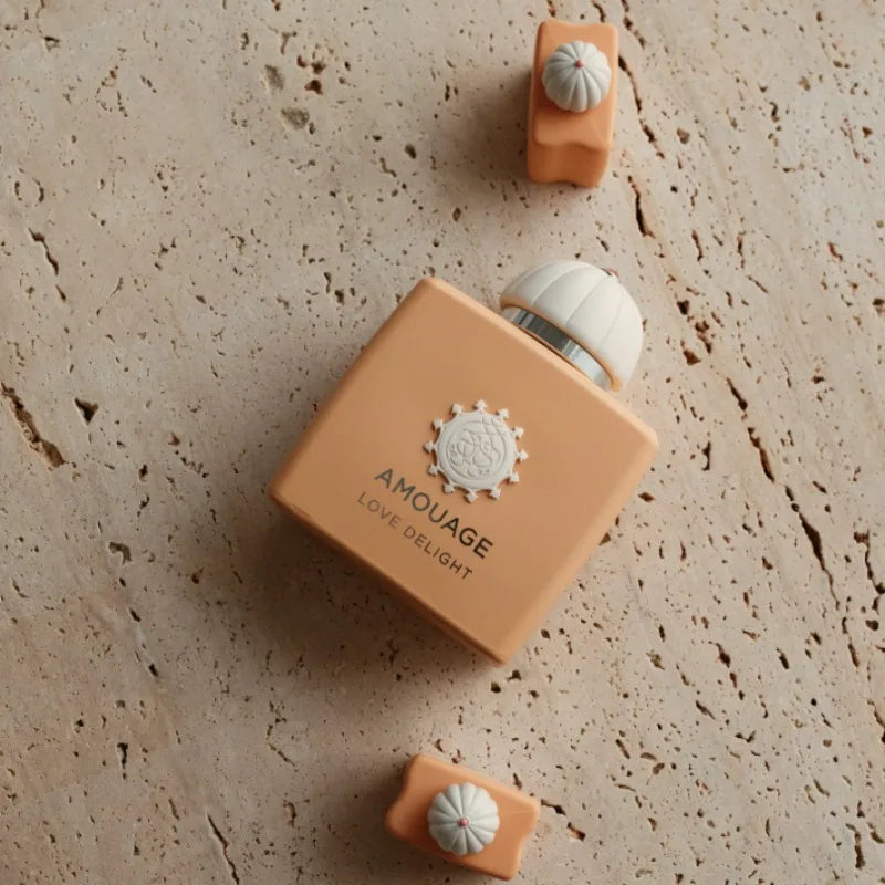 Amouage Love Delight Eau de Parfum, a long-lasting feminine fragrance in a square peach bottle with a unique white cap.